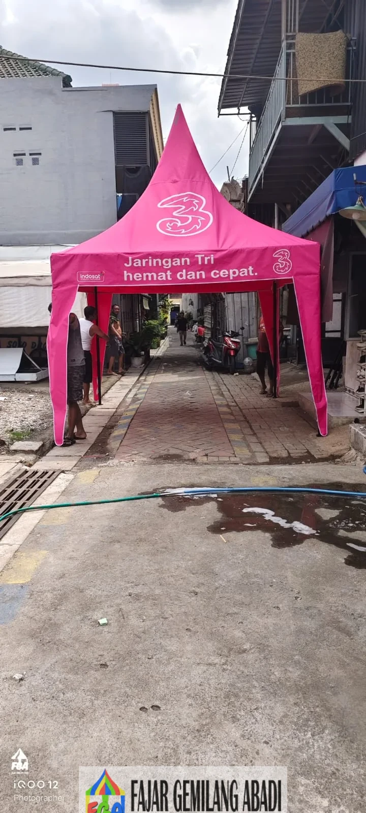 Contoh tenda kerucut promosi berwarna pink dengan branding Three